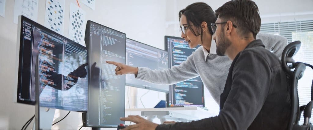 Two cybersecurity experts analyzing computer code to fix a chrome memory vulnerability leak